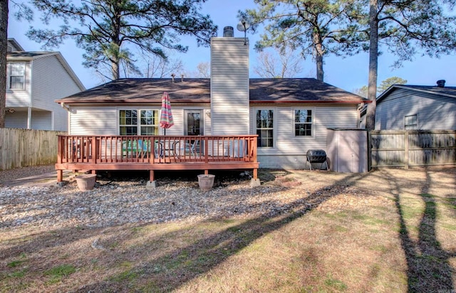 back of house featuring a chimney, fence, a deck, and a gate