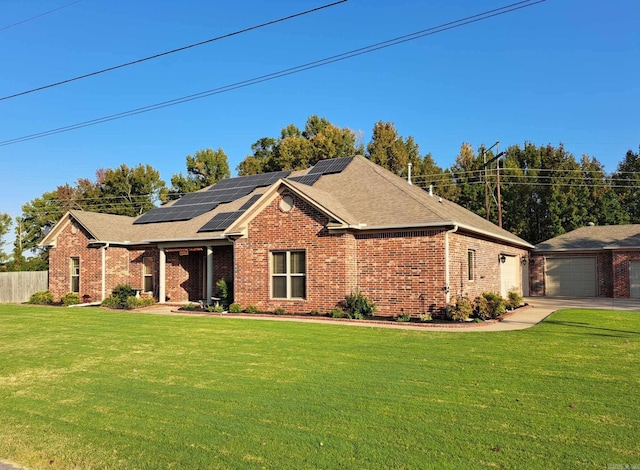 view of front of home featuring a front yard, roof mounted solar panels, fence, and brick siding