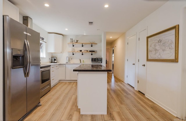 kitchen with a kitchen island, visible vents, white cabinets, appliances with stainless steel finishes, and open shelves