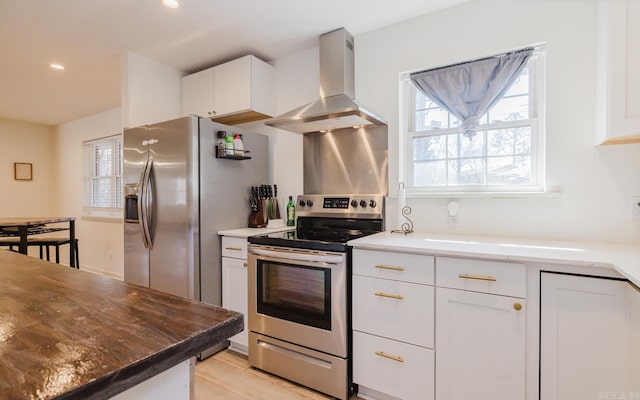 kitchen featuring white cabinets, appliances with stainless steel finishes, extractor fan, and recessed lighting