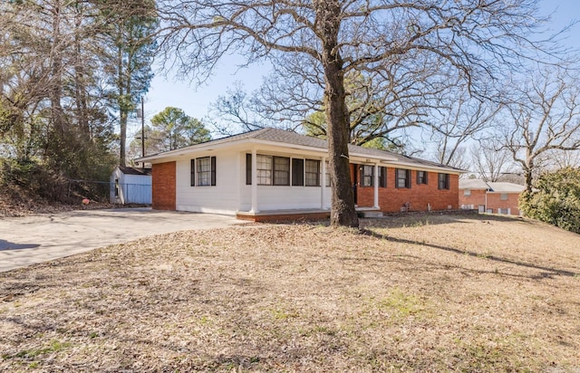 ranch-style home featuring concrete driveway and brick siding