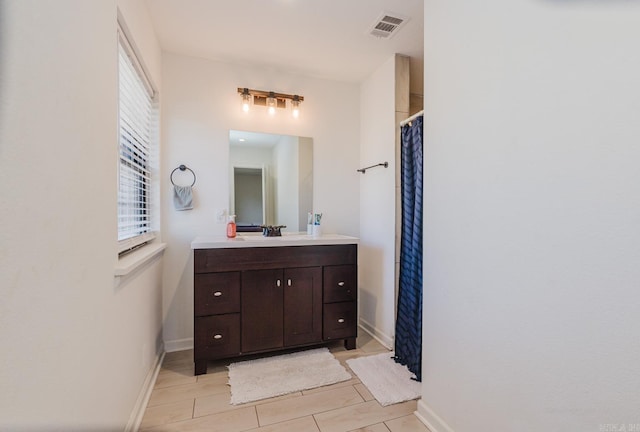 bathroom featuring baseboards, visible vents, tile patterned flooring, and vanity