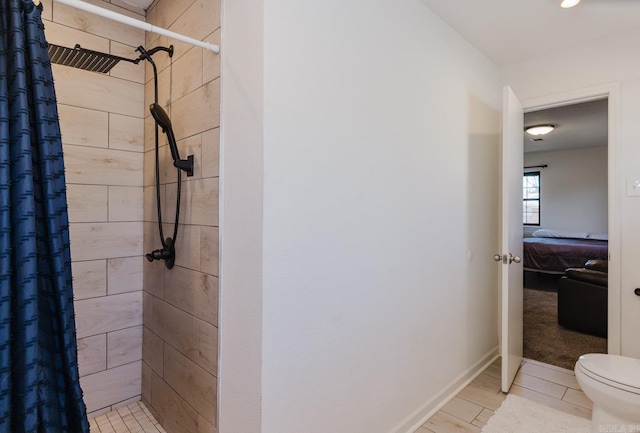 ensuite bathroom with toilet, a stall shower, baseboards, and ensuite bathroom