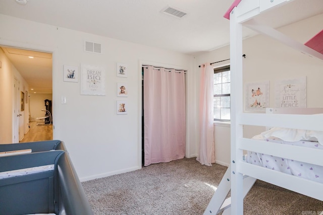 bedroom with light carpet, visible vents, and baseboards