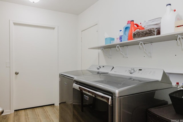 laundry room with laundry area, light wood-style flooring, and separate washer and dryer