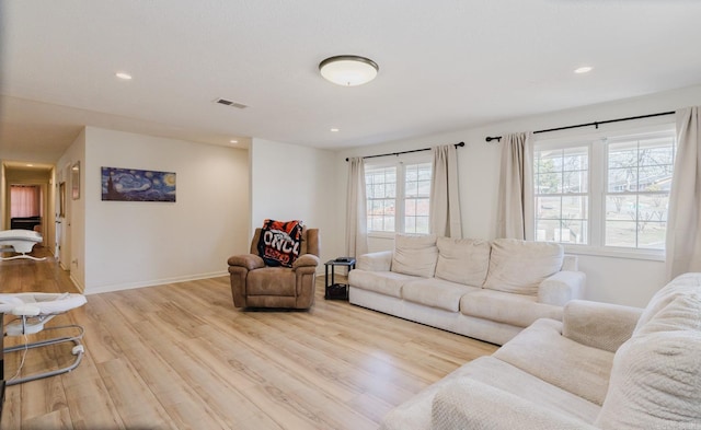 living room featuring light wood-type flooring, baseboards, visible vents, and recessed lighting