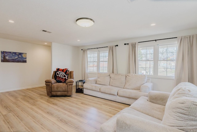 living area featuring light wood-type flooring, baseboards, and recessed lighting