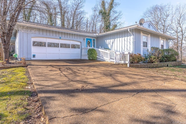 single story home with an attached garage, board and batten siding, and concrete driveway