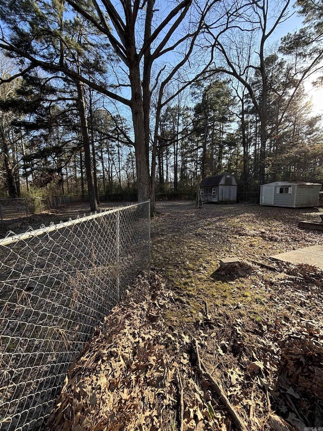 view of yard with an outdoor structure, a storage shed, and fence