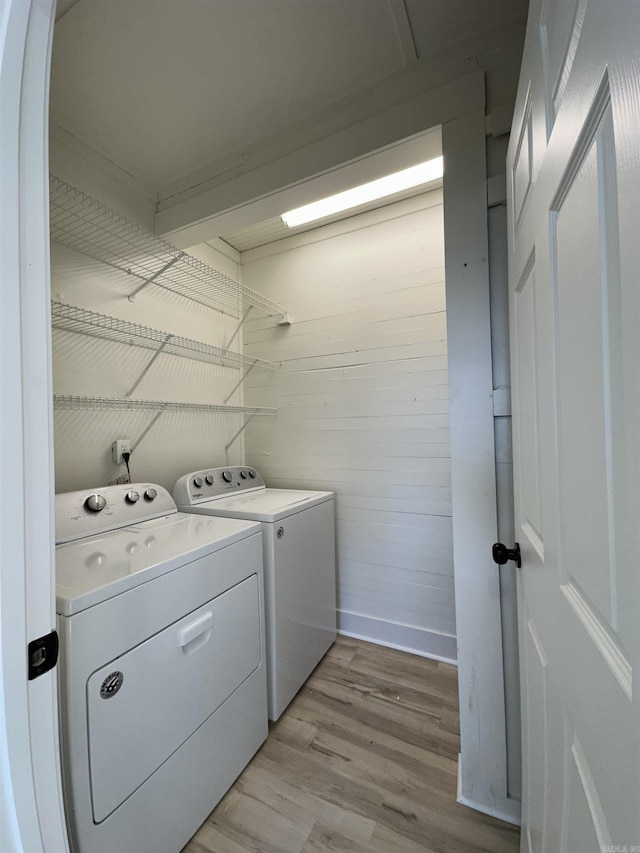 laundry room featuring laundry area, washer and clothes dryer, and light wood-style flooring