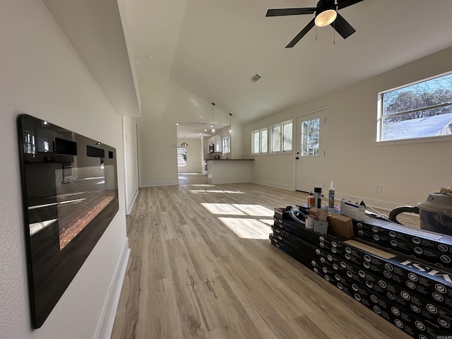 living area featuring baseboards, plenty of natural light, visible vents, and light wood-style floors