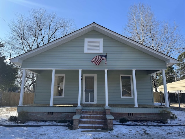 bungalow-style home with covered porch, crawl space, and fence