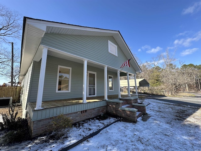 view of front of house with a porch, crawl space, and fence