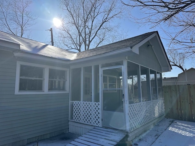 view of home's exterior featuring a sunroom and fence