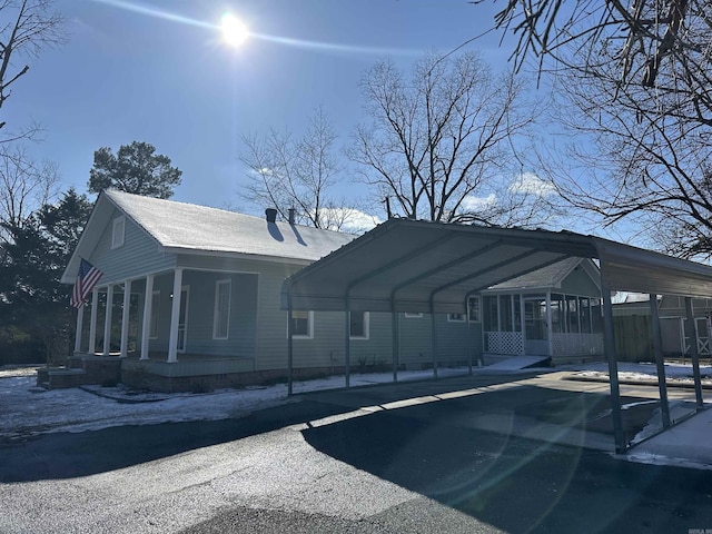 exterior space with driveway, a chimney, and a detached carport