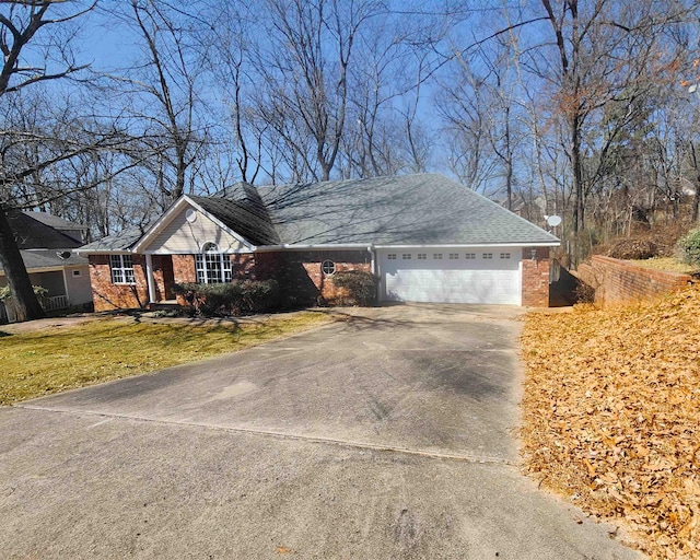 ranch-style house with driveway, an attached garage, a front yard, and brick siding