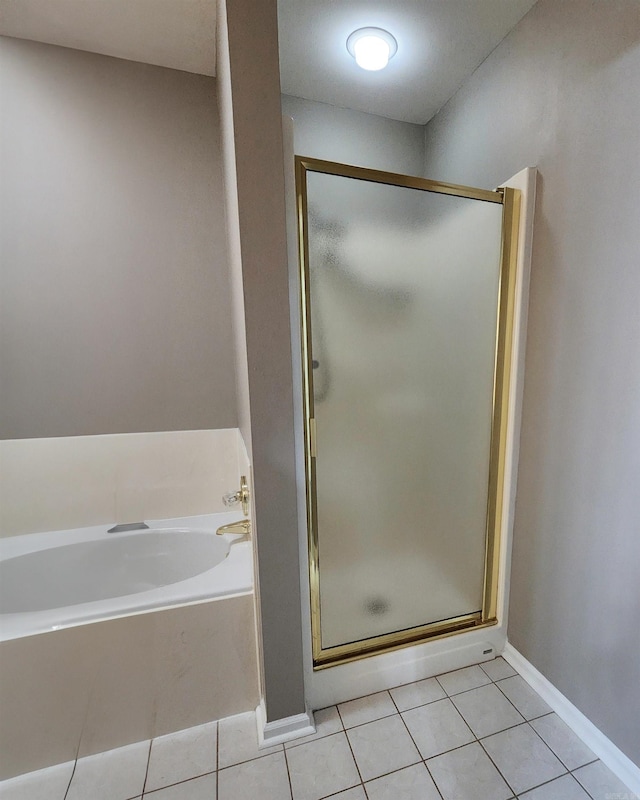 full bathroom with a stall shower, tile patterned flooring, baseboards, and a bath