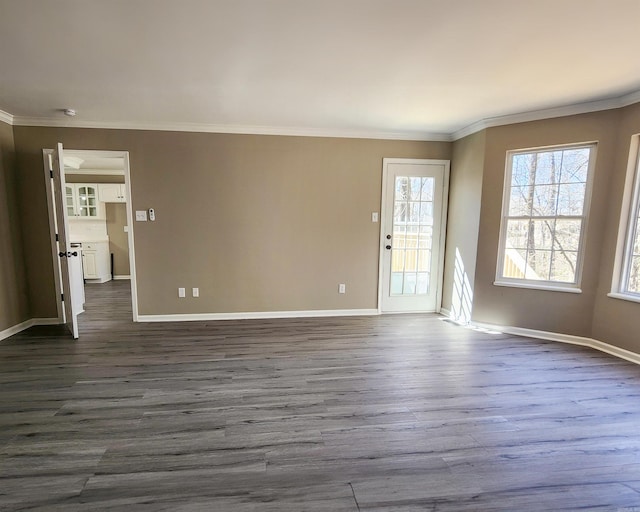 interior space featuring ornamental molding, dark wood-style flooring, and baseboards