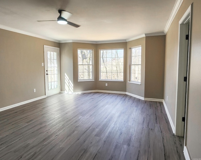 spare room with dark wood-style floors, crown molding, baseboards, and ceiling fan