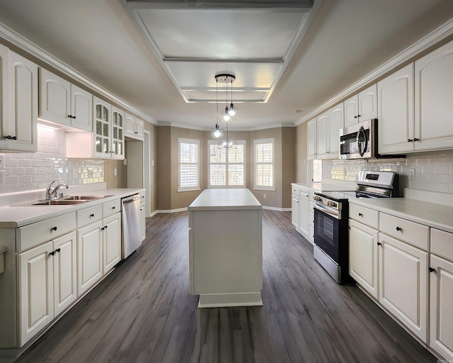 kitchen with stainless steel appliances, hanging light fixtures, light countertops, and glass insert cabinets