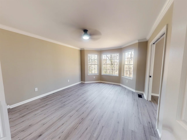 empty room with visible vents, light wood-style flooring, ornamental molding, a ceiling fan, and baseboards