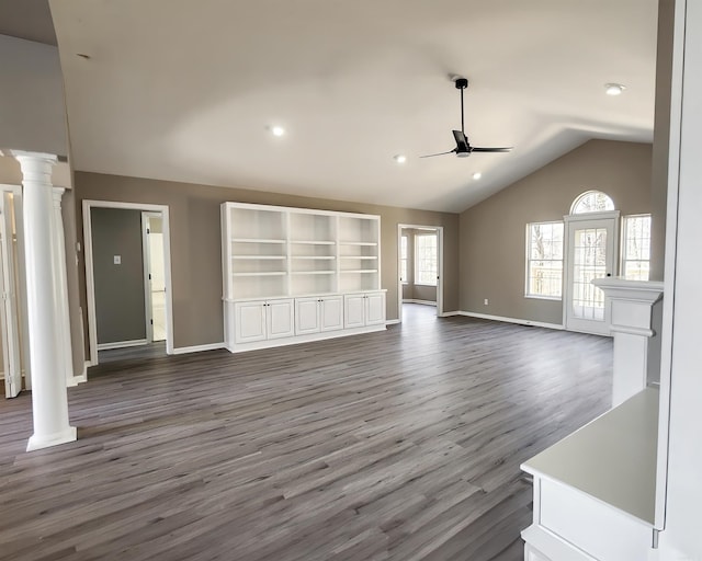 unfurnished living room featuring ornate columns, vaulted ceiling, ceiling fan, wood finished floors, and baseboards