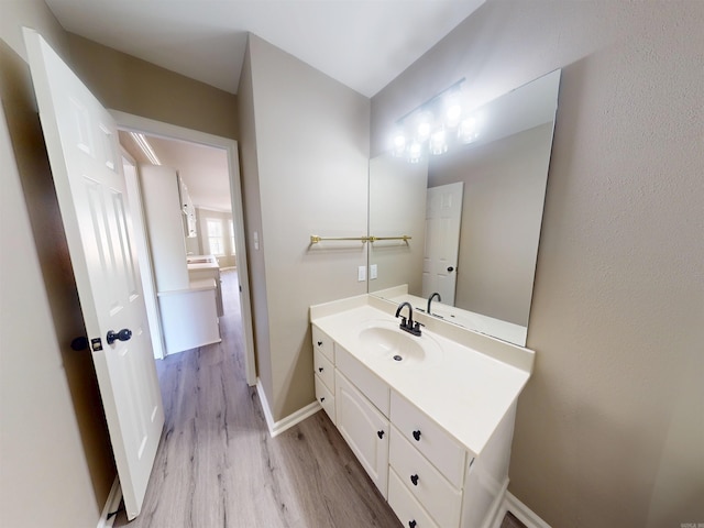 bathroom featuring baseboards, wood finished floors, and vanity