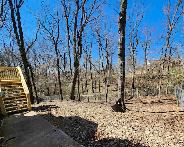 view of yard featuring fence and stairway