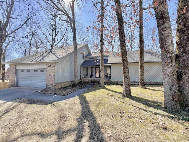 view of front of property featuring a garage, concrete driveway, and brick siding