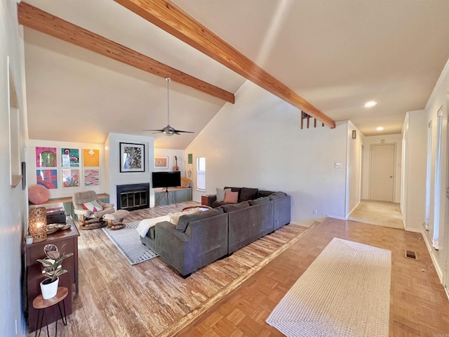 living area with lofted ceiling with beams, recessed lighting, visible vents, a ceiling fan, and a glass covered fireplace