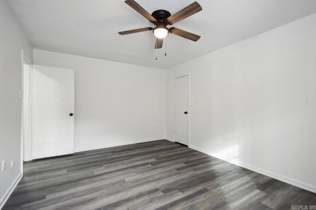 unfurnished room featuring a textured ceiling, dark wood finished floors, a ceiling fan, and baseboards