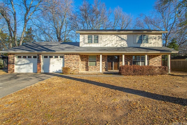 view of front of house featuring driveway, an attached garage, a porch, and brick siding