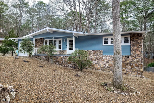 ranch-style home with covered porch and stone siding