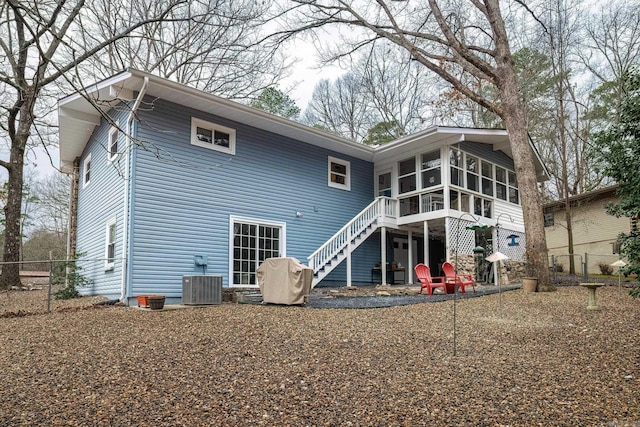 rear view of house with stairway, cooling unit, fence, and a sunroom