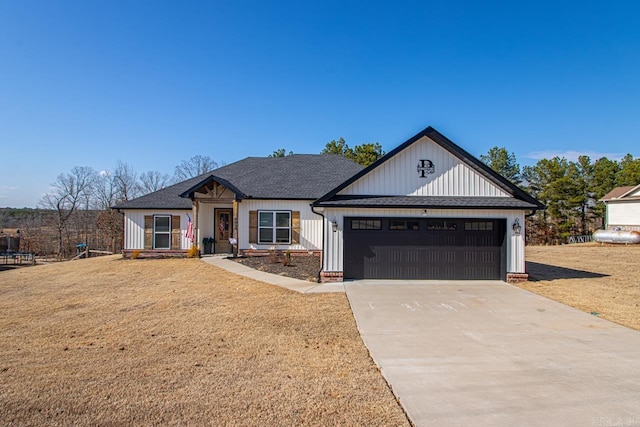 modern farmhouse with a garage, concrete driveway, a shingled roof, and a front yard