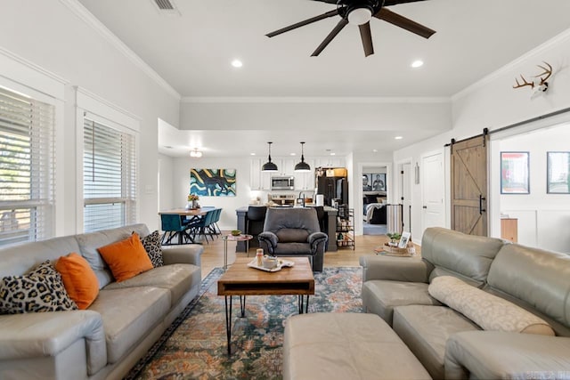 living room featuring recessed lighting, a barn door, ornamental molding, a ceiling fan, and wood finished floors