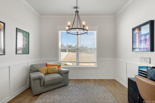 sitting room with light wood-style flooring, visible vents, a chandelier, and crown molding