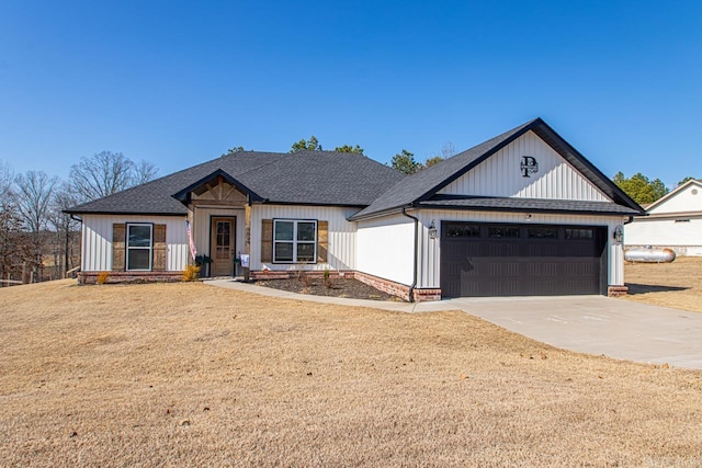 modern inspired farmhouse featuring a shingled roof, concrete driveway, a front lawn, and a garage