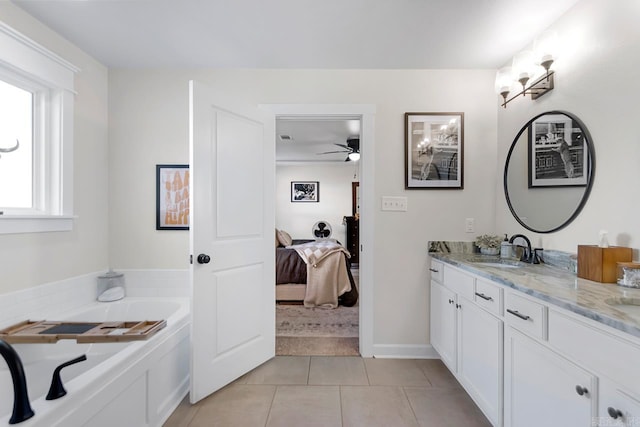 bathroom with double vanity, ensuite bath, ceiling fan, tile patterned floors, and a sink