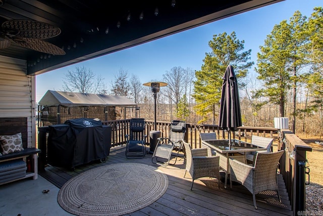 wooden terrace with ceiling fan, outdoor dining space, and area for grilling