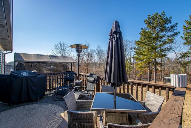 wooden terrace with grilling area and outdoor dining space