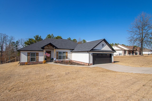 view of front of house with driveway, an attached garage, a front lawn, and roof with shingles