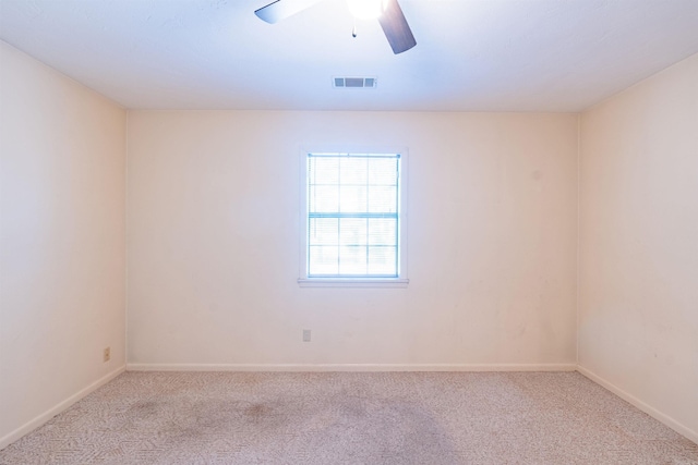 empty room with baseboards, a ceiling fan, visible vents, and light colored carpet