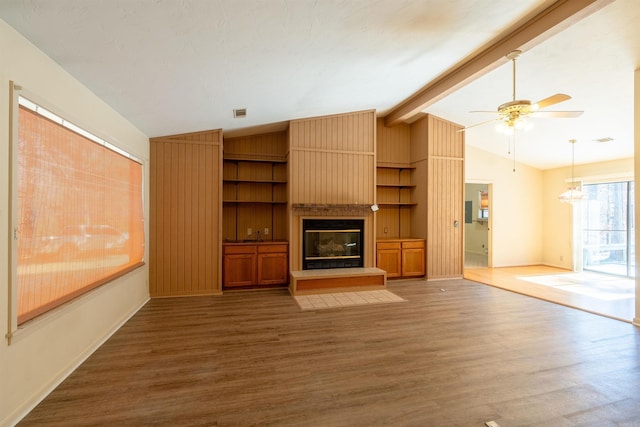 unfurnished living room featuring lofted ceiling with beams, a large fireplace, a ceiling fan, baseboards, and dark wood-style floors