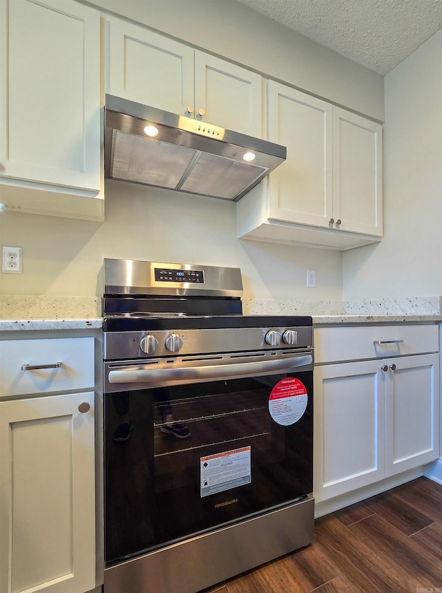 kitchen with white cabinets, electric stove, dark wood-style floors, light stone counters, and exhaust hood