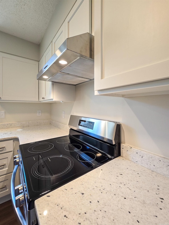 kitchen featuring white cabinets, ventilation hood, and stainless steel range with electric cooktop