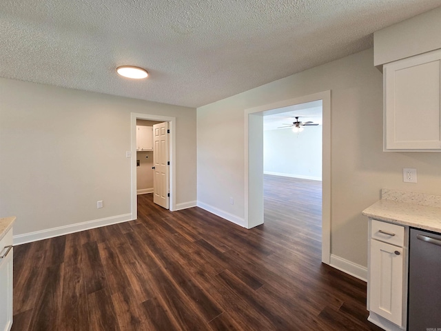 interior space with dark wood-style floors, a textured ceiling, and baseboards