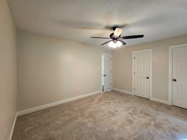 unfurnished bedroom featuring ceiling fan, carpet, visible vents, and baseboards