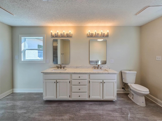 full bath with baseboards, a sink, toilet, and double vanity