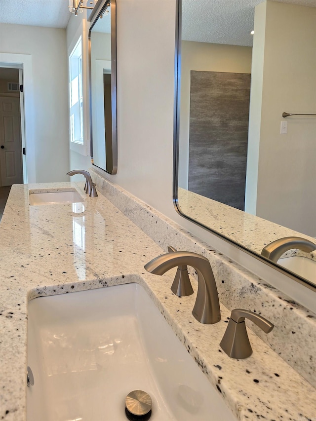 bathroom featuring visible vents and a textured ceiling